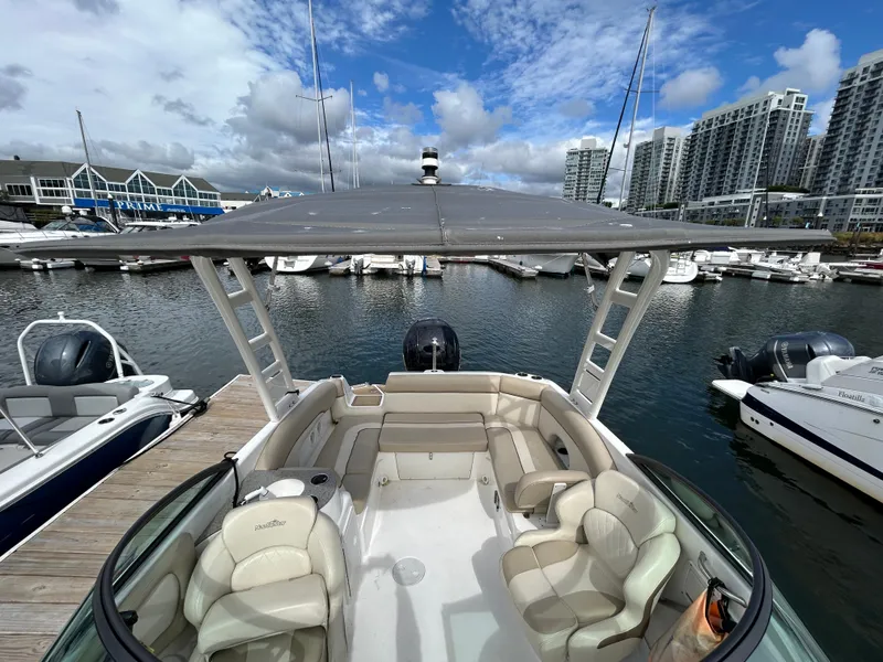 Slide: The Image of 2022 NauticStar 243 DC boat docked in marina with cityscape background. - 20