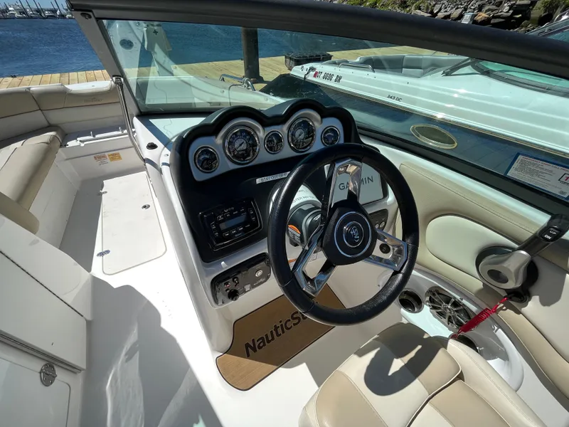 Slide: The Image of 2022 NauticStar 243 DC boat interior with steering wheel and dashboard controls. - 24