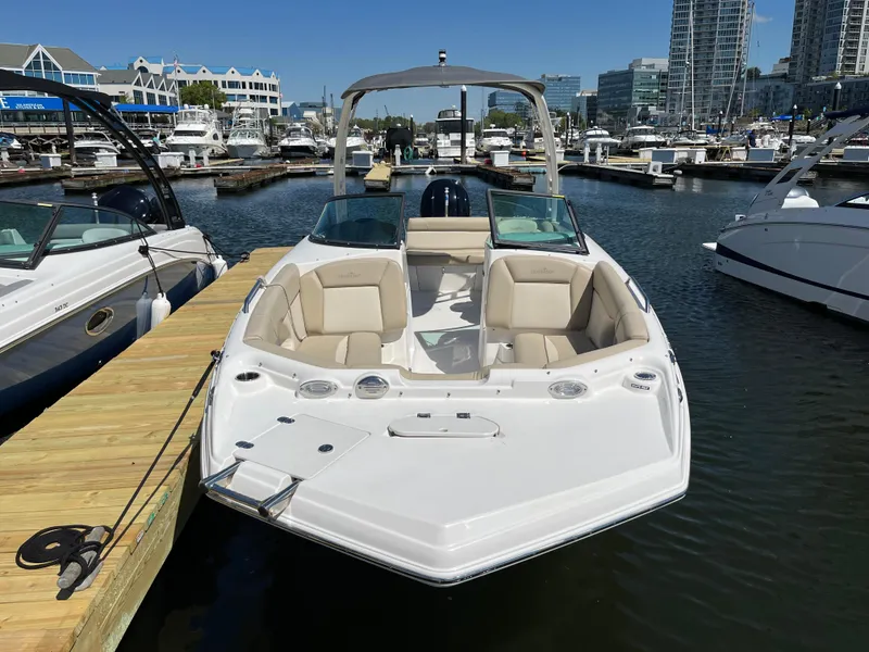 Slide: The Image of 2022 NauticStar 243 DC boat docked in a marina with cityscape background. - 4