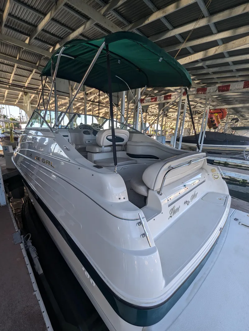 Slide: The Image of 1997 Regal Commodore 242 boat with canopy, docked in a covered marina. - 2