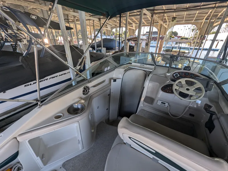 Slide: The Image of 1997 Regal Commodore 242 boat interior with steering wheel and seating under a canopy. - 3