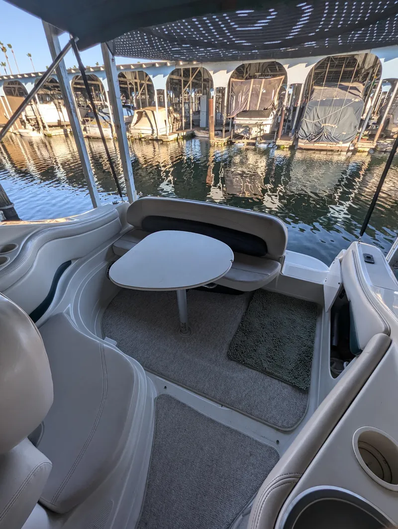 Slide: The Image of 1997 Regal Commodore 242 boat interior with seating and table, docked at marina. - 9