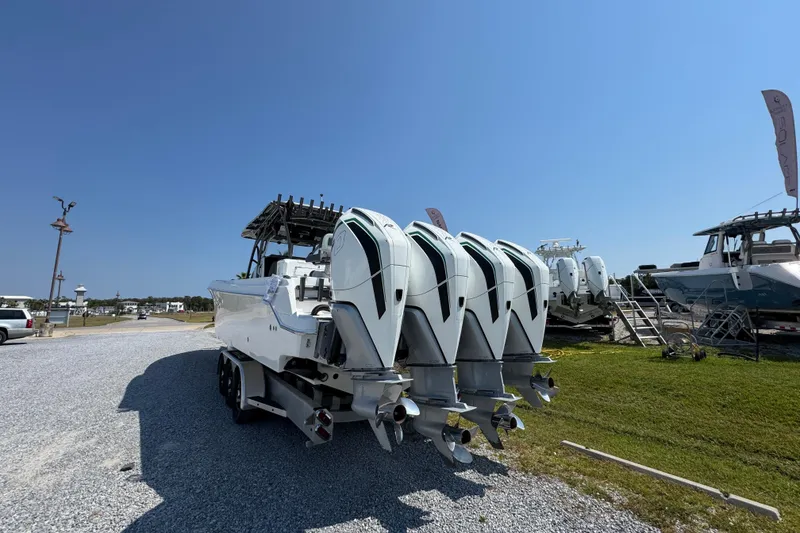 Slide: The Image of 2022 Nor-Tech 392 Super Fish boat with four powerful outboard engines, parked on gravel. - 5