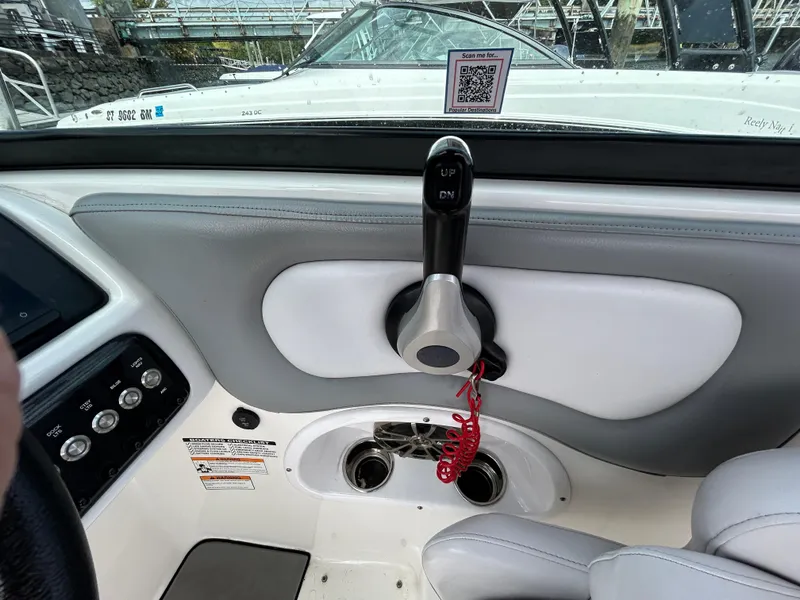 Slide: The Image of 2022 NauticStar 243 DC boat interior with control panel and throttle lever. - 13