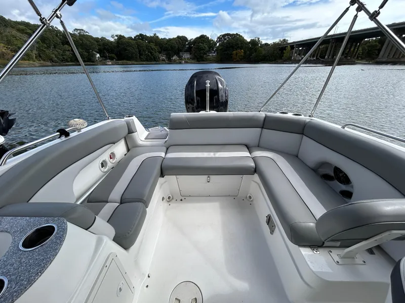 Slide: The Image of 2022 NauticStar 243 DC boat interior with spacious seating on a calm lake. - 15