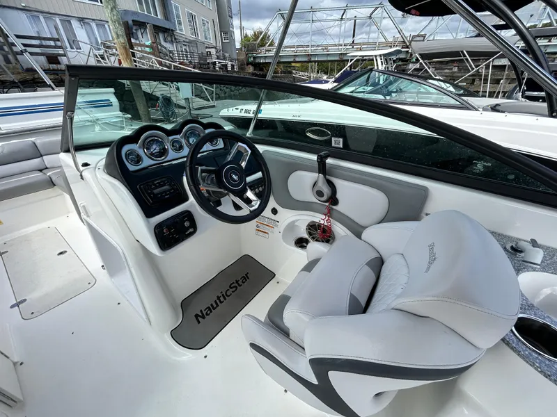 Slide: The Image of 2022 NauticStar 243 DC boat interior with steering wheel and dashboard controls. - 16