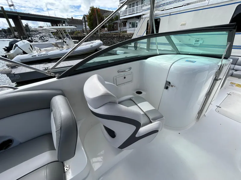 Slide: The Image of 2022 NauticStar 243 DC boat interior with seating and console, docked at marina. - 17