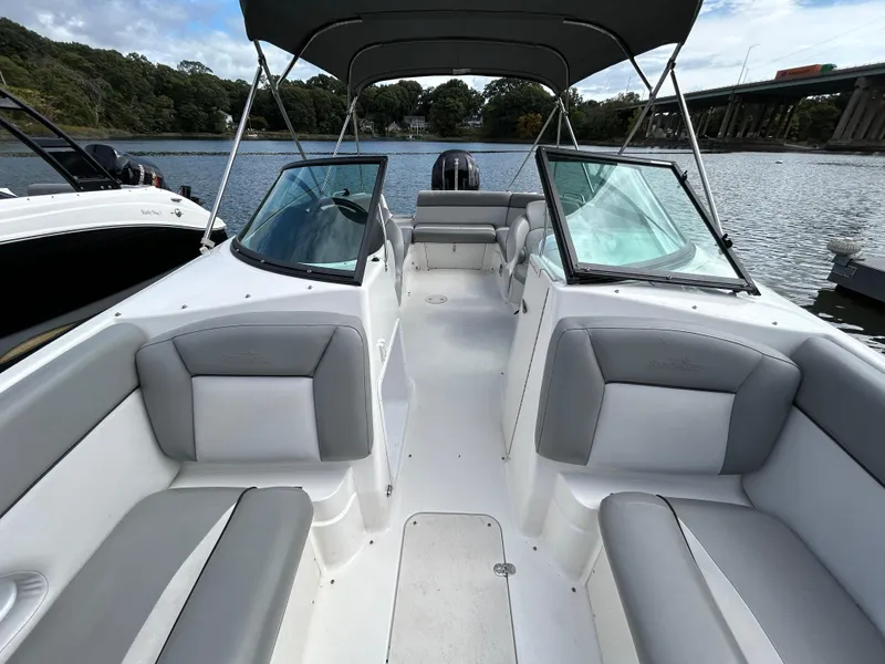 Slide: The Image of 2022 NauticStar 243 DC boat interior with gray seating, open water view. - 22
