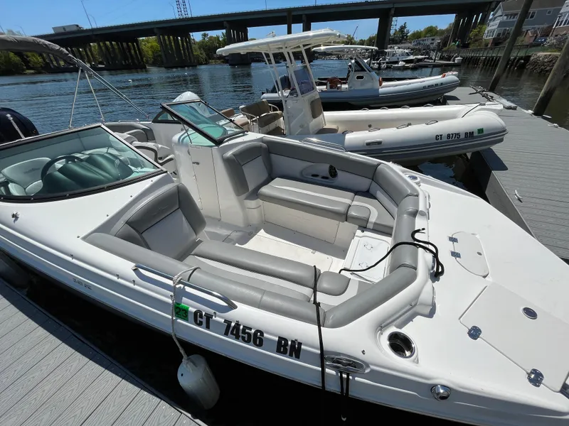 Slide: The Image of 2022 NauticStar 243 DC boat docked at marina, featuring spacious seating and sleek design. - 25