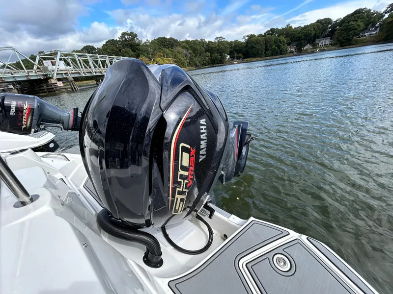 Slide: The Image of NauticStar 243 DC boat with Yamaha outboard engine on a calm lake, 2022 model. - 8