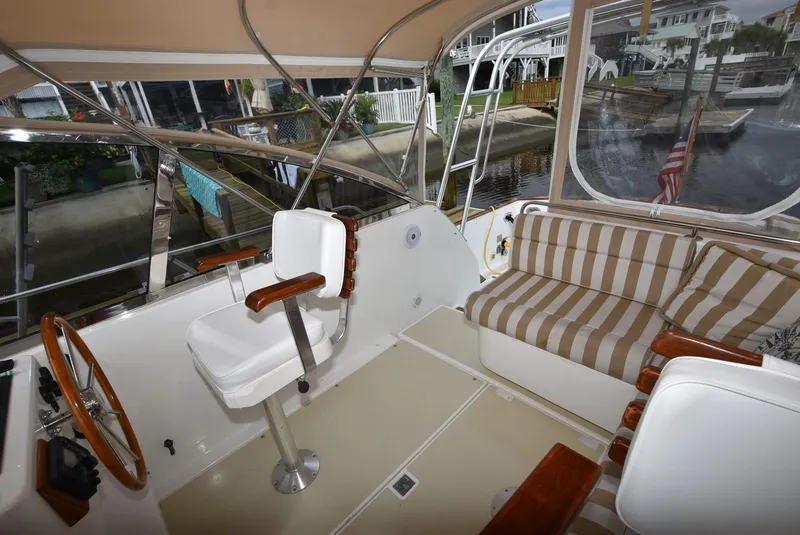 Slide: The Image of 1999 Legacy 34 Express boat interior with seating and helm station. - 12