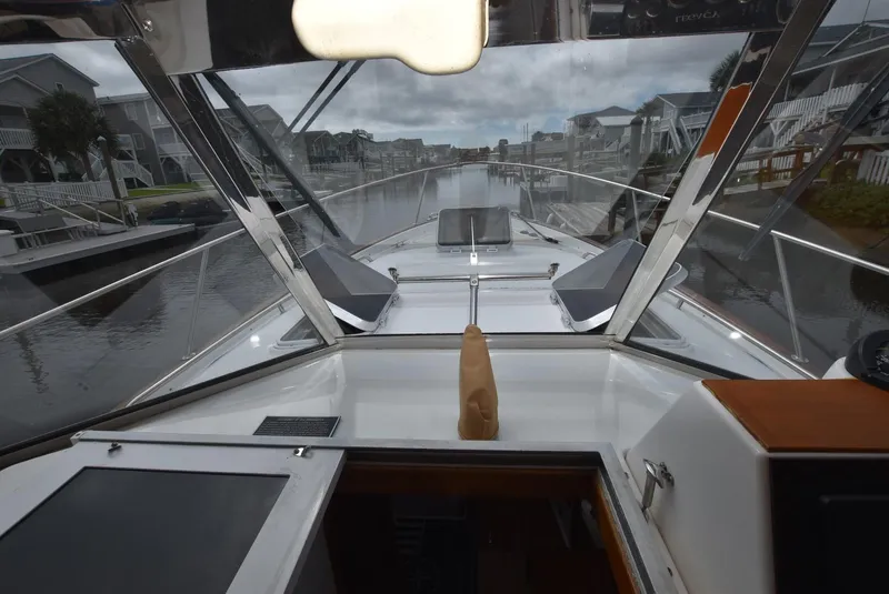 Slide: The Image of 1999 Legacy 34 Express boat interior view, featuring sleek design and canal backdrop. - 13