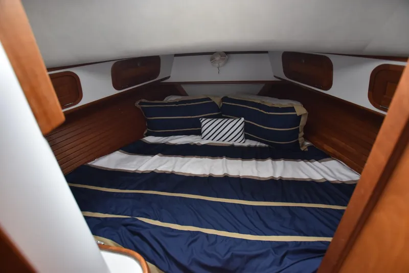 Slide: The Image of Cozy cabin interior of 1999 Legacy 34 Express with striped bedding. - 17