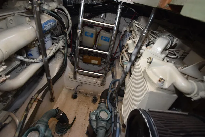 Slide: The Image of Engine room of 1999 Legacy 34 Express boat with visible machinery and ladder. - 22