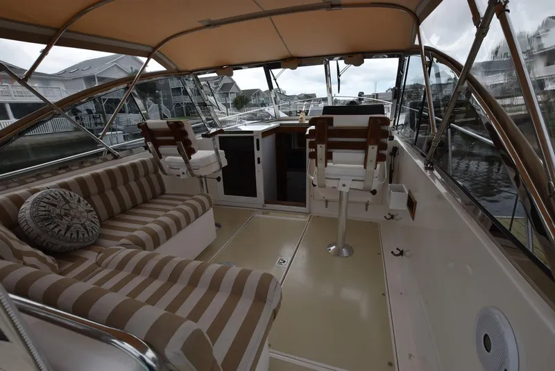 Slide: The Image of Interior of 1999 Legacy 34 Express boat with striped seating and helm station. - 5