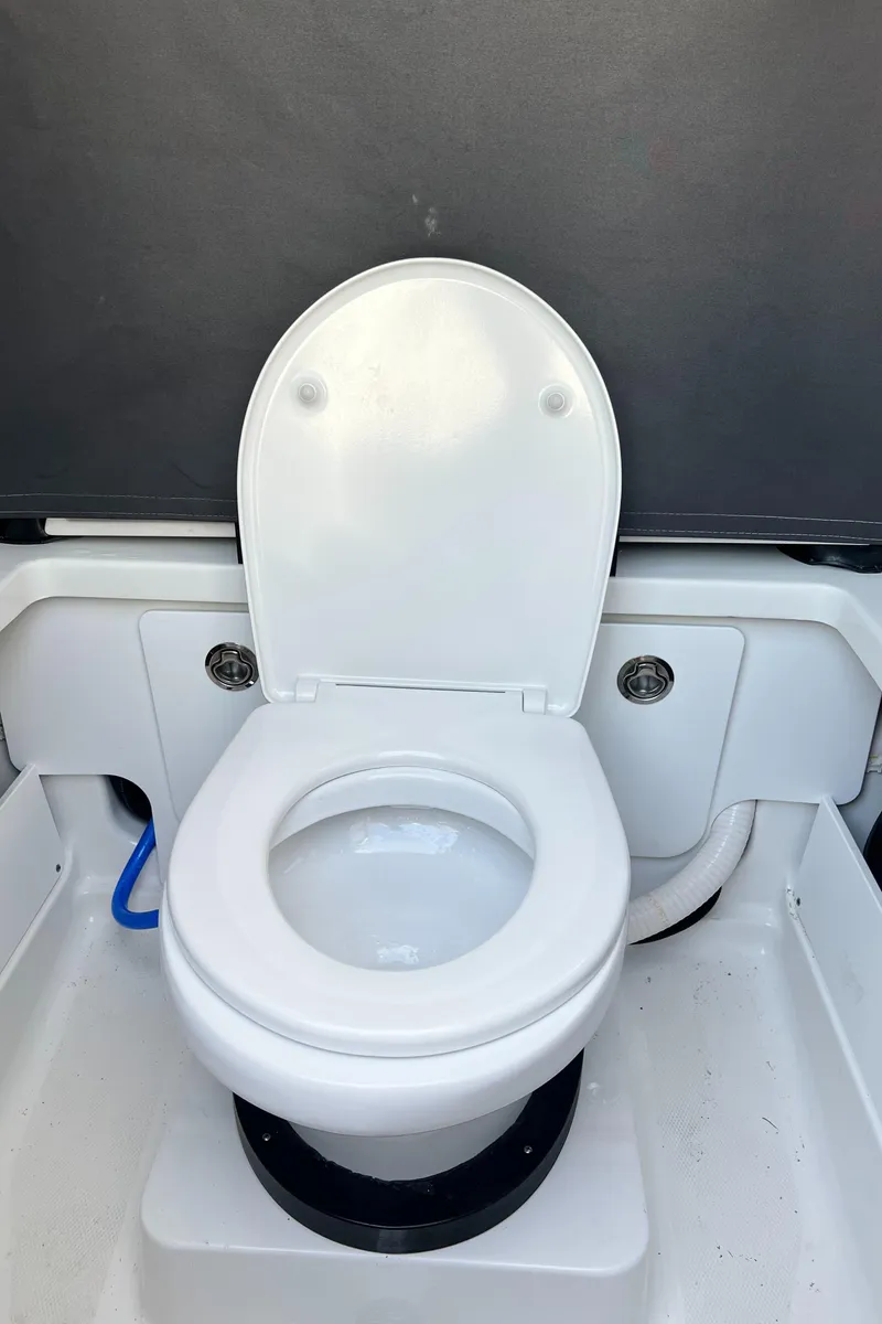 Slide: The Image of 2023 Blackfin 252 CC boat toilet interior with white seat and modern design. - 15