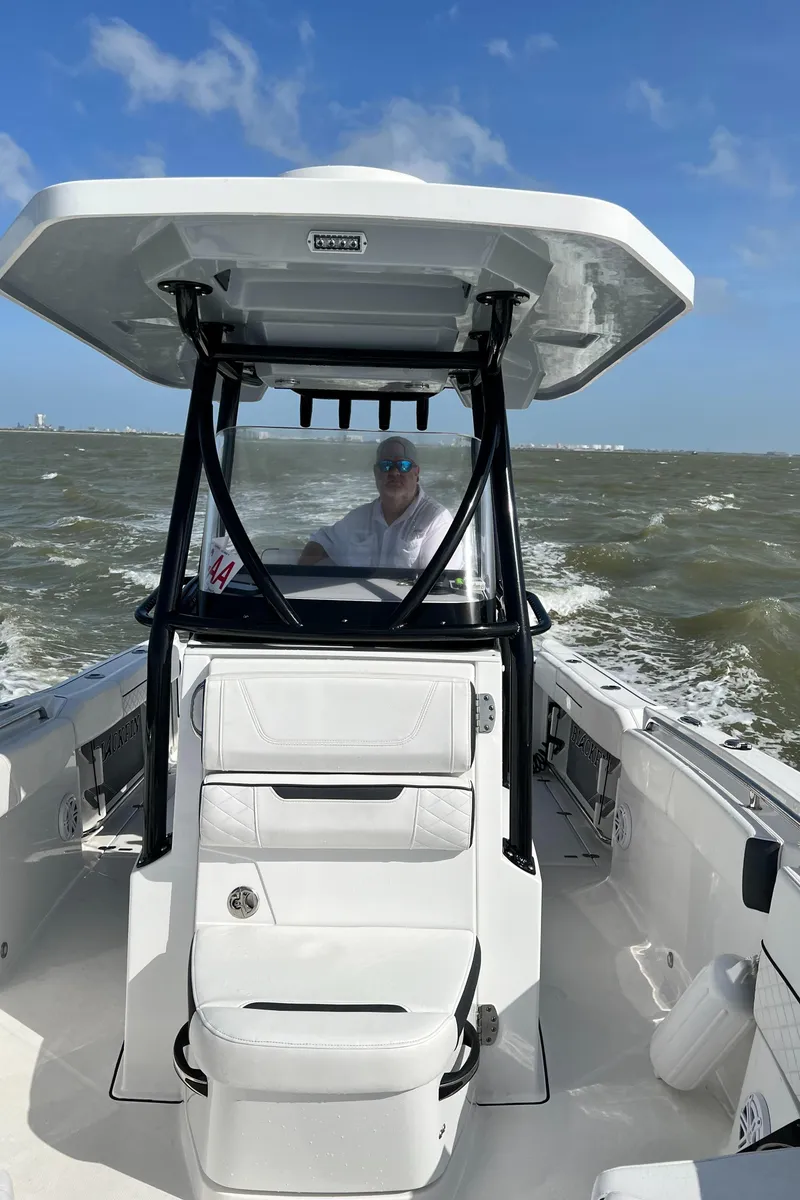 Slide: The Image of 2023 Blackfin 252 CC boat navigating choppy waters under a clear blue sky. - 17