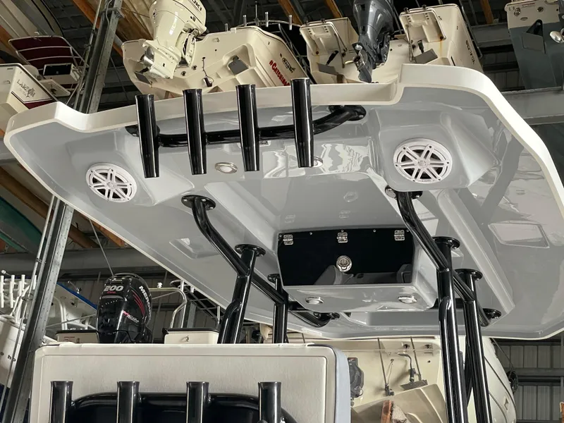 Slide: The Image of 2023 Blackfin 252 CC boat with mounted speakers and rod holders in a showroom. - 23