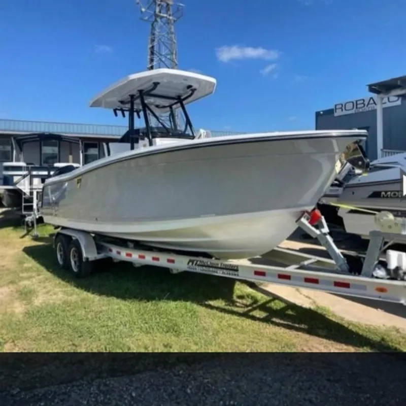 Slide: The Image of 2023 Blackfin 252 CC boat on trailer, displayed outdoors. - 27