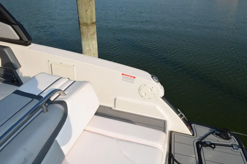 Slide: The Image of 2020 Chaparral 257 SSX boat interior with seating, docked by calm water. - 13
