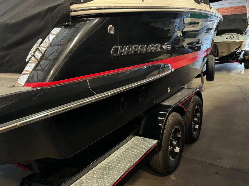 Slide: The Image of 2020 Chaparral 257 SSX boat in a garage, black with red accents, on a trailer. - 22