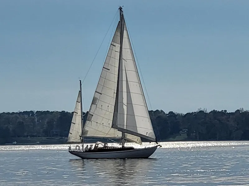 Slide: The Image of Historic 1938 Barkhouse Custom 44 Yawl sailing on a serene, sunlit lake. - 3