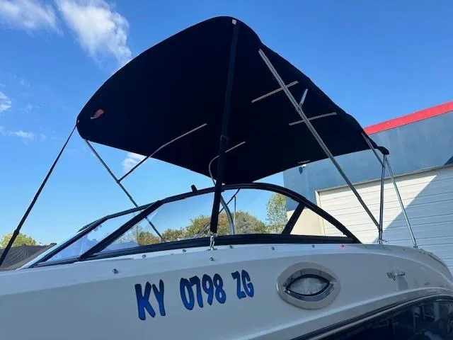 Slide: The Image of 2018 Bayliner VR6 Bowrider I/O with canopy, docked under clear blue sky. - 10