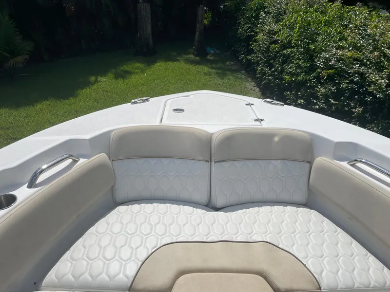 Slide: The Image of 2021 Sea Fox 248 Commander boat with cushioned seating and lush greenery background. - 3