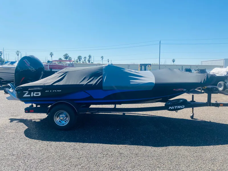 Slide: The Image of 2023 Nitro Z18 boat covered on trailer in sunny outdoor setting. - 10