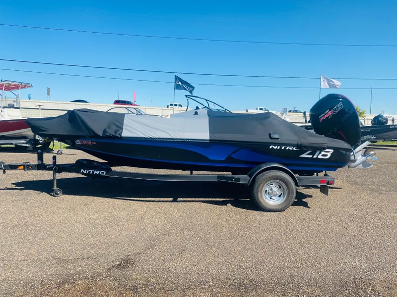 Slide: The Image of 2023 Nitro Z18 boat with cover on trailer, parked outdoors. - 11