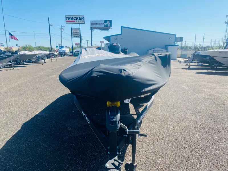 Slide: The Image of 2023 Nitro Z18 boat covered, parked at dealership lot under clear blue sky. - 6