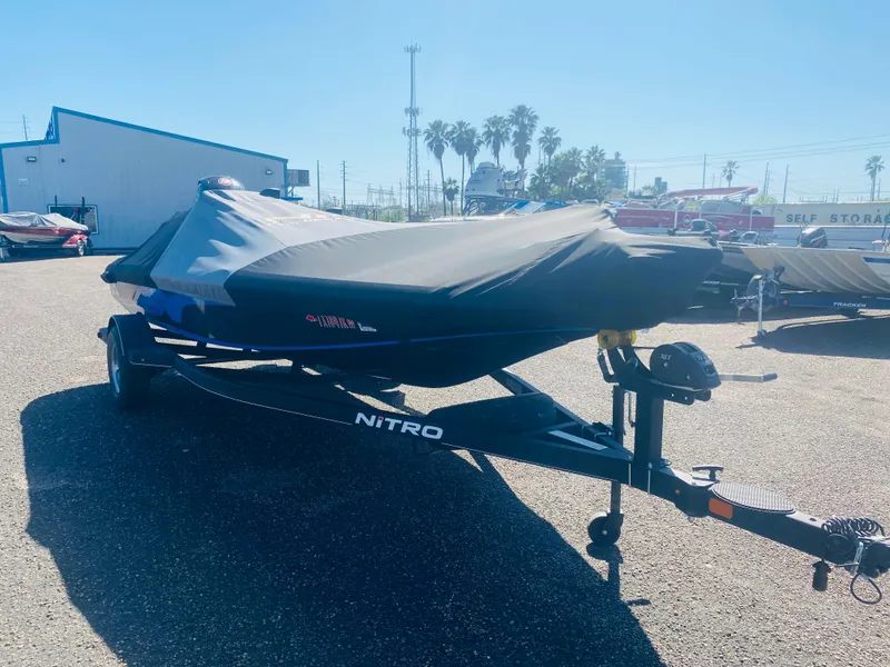 Slide: The Image of 2023 Nitro Z18 boat covered on trailer in sunny outdoor storage area. - 7