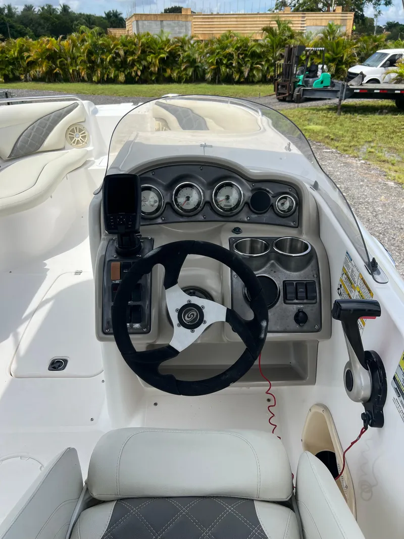 Slide: The Image of 2011 Hurricane SUNDECK SPORT 220 boat dashboard with steering wheel and gauges. - 11
