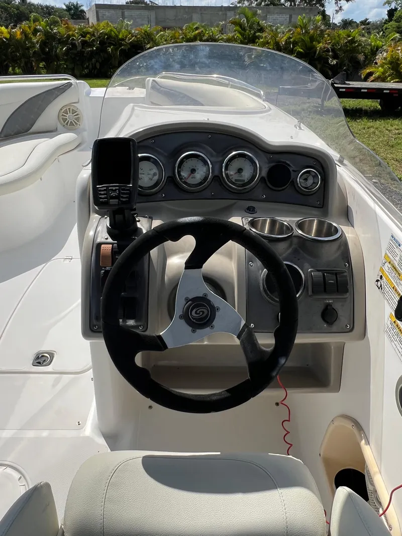 Slide: The Image of 2011 Hurricane SUNDECK SPORT 220 boat dashboard with steering wheel and gauges. - 13