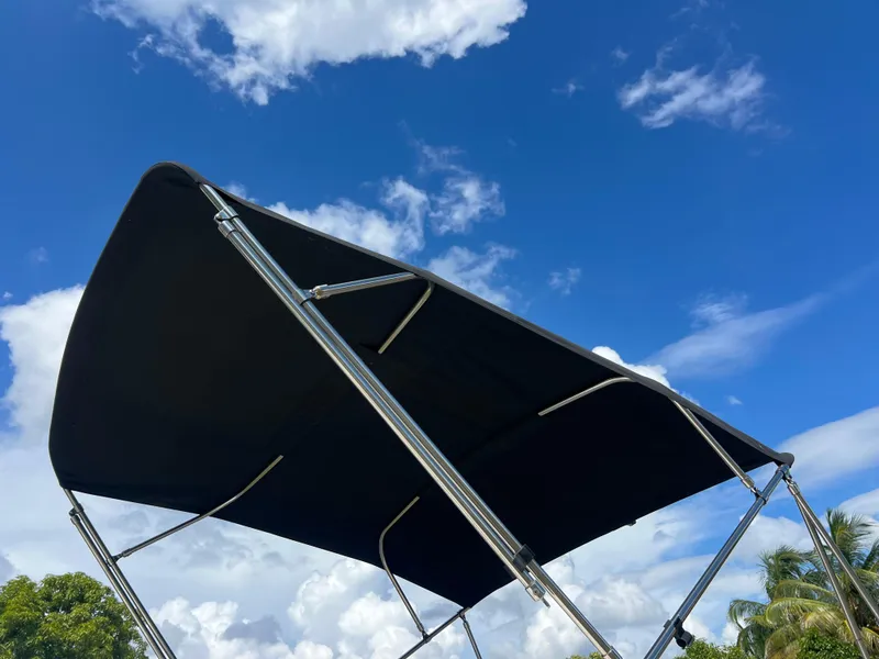 Slide: The Image of 2011 Hurricane SUNDECK SPORT 220 boat canopy against blue sky. - 16