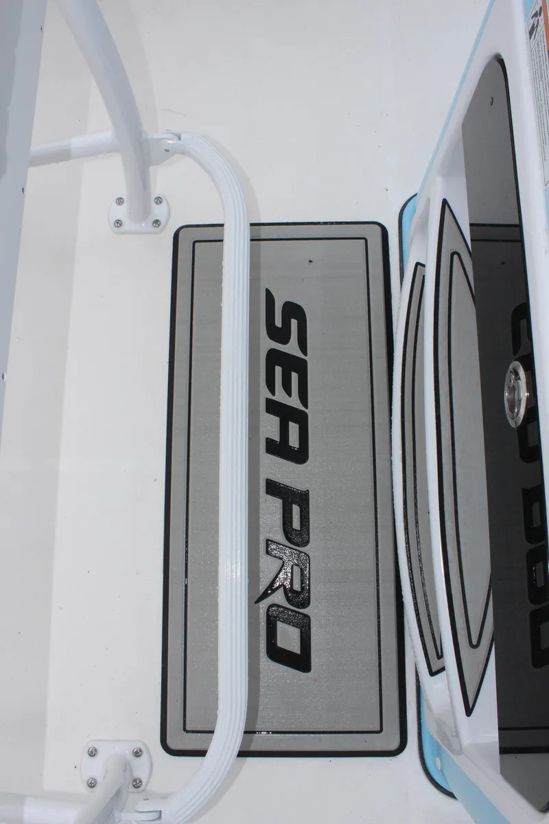 Slide: The Image of 2025 Sea Pro 250 Bay boat interior with branded mat and sleek design. - 26