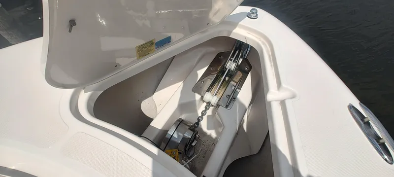 Slide: The Image of 2015 Pursuit S 280 Sport anchor compartment with open hatch, showcasing chain and winch. - 18