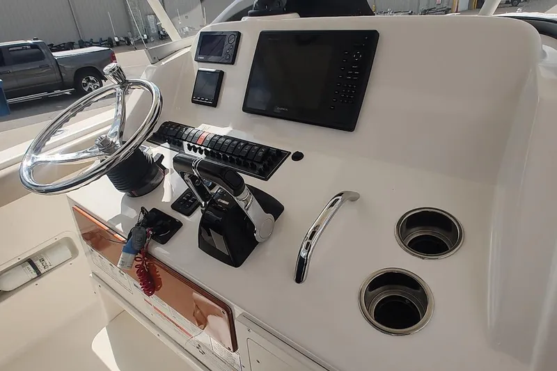 Slide: The Image of 2015 Pursuit S 280 Sport boat dashboard with steering wheel and controls. - 22