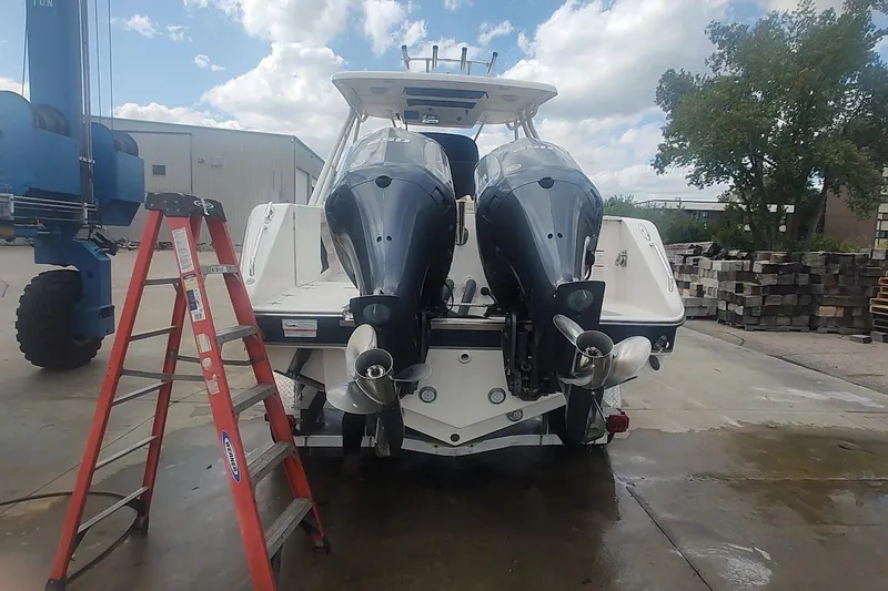 Slide: The Image of 2015 Pursuit S 280 Sport boat with dual outboard motors on a dock. - 23