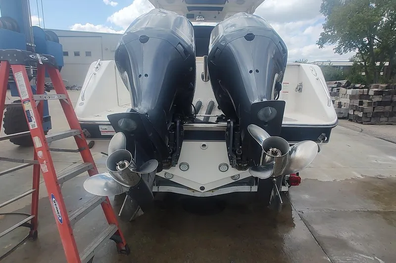 Slide: The Image of 2015 Pursuit S 280 Sport boat with dual outboard motors in a marina setting. - 26
