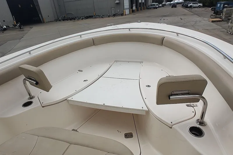 Slide: The Image of 2015 Pursuit S 280 Sport boat interior with seating and table in a dock setting. - 44