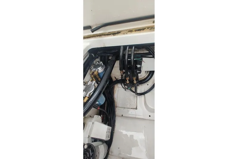 Slide: The Image of Engine compartment of 2015 Pursuit S 280 Sport boat with visible hoses and components. - 45