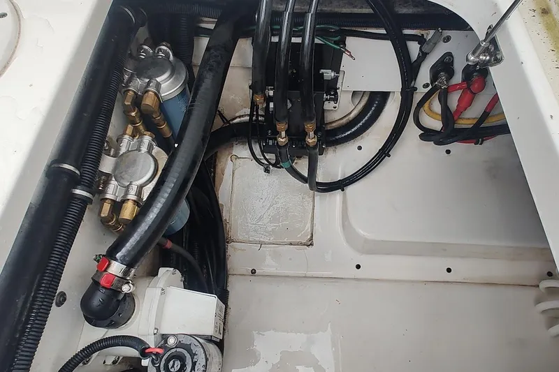 Slide: The Image of Engine compartment of a 2015 Pursuit S 280 Sport boat, showing hoses and components. - 48