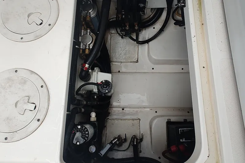 Slide: The Image of Engine compartment of a 2015 Pursuit S 280 Sport boat, showing mechanical components and wiring. - 49