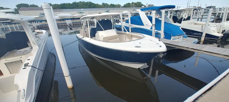 Slide: The Image of 2015 Pursuit S 280 Sport boat docked at marina, surrounded by other vessels. - 6