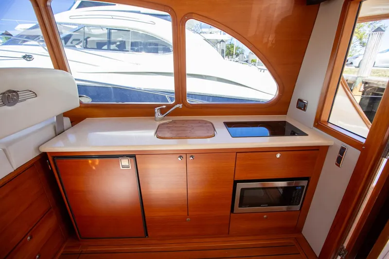 Slide: The Image of Luxurious 2017 Palm Beach PB42 yacht interior with kitchenette and modern amenities. - 13