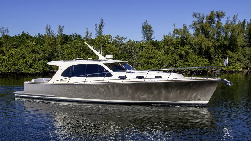 Slide: The Image of 2017 Palm Beach PB42 yacht cruising on a serene waterway with lush greenery. - 2