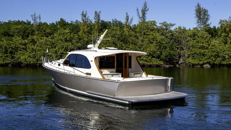 Slide: The Image of 2017 Palm Beach PB42 yacht cruising on a serene waterway, surrounded by lush greenery. - 3