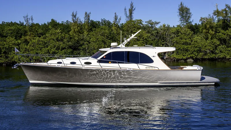 Slide: The Image of 2017 Palm Beach PB42 yacht on calm water, surrounded by lush greenery. - 31