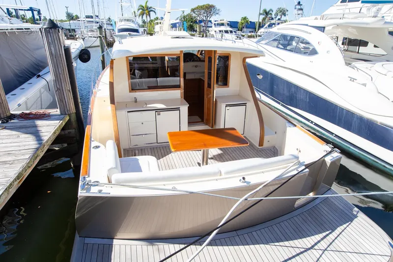 Slide: The Image of 2017 Palm Beach PB42 yacht docked, featuring spacious deck and seating area. - 9